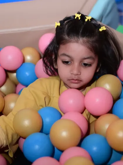 A young guest enjoying the colorful ball pit.