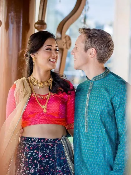 A lovely portrait of a couple looking at each other with adoration. The framing through a foreground element adds depth and a sense of peeking into a private, happy moment.