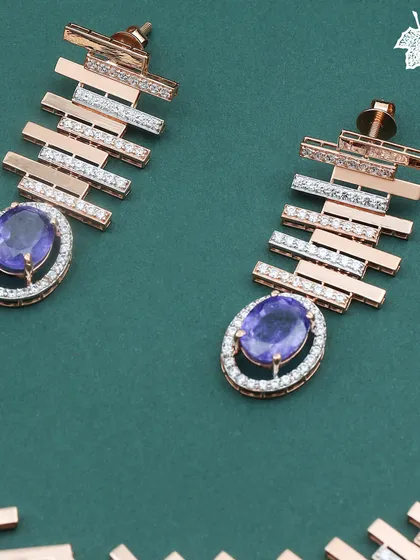 Rule every moment with the Royal Blue brilliance of this modern set. The earrings feature a bold, architectural design with bars of rose gold and diamonds, culminating in a deep blue oval gemstone.