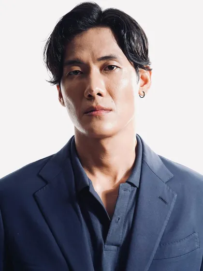 A clean, professional headshot. The grooming is minimal and natural, focusing on healthy-looking skin and neat, contemporary hair styling.