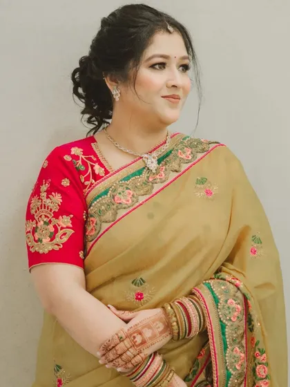 A sophisticated look for a family function. The makeup is subtle and elegant, paired with a classic updo that complements her beautiful saree.