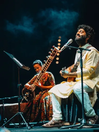A close-up shot of Anoushka Shankar and a fellow musician sharing a moment of deep musical connection on stage.