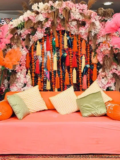 For this Mehendi, I went all-out with a bohemian and colourful theme. The backdrop features a dense arrangement of flowers, pampas grass, and vibrant tassels, creating a fun and high-energy setting perfect for the celebration.