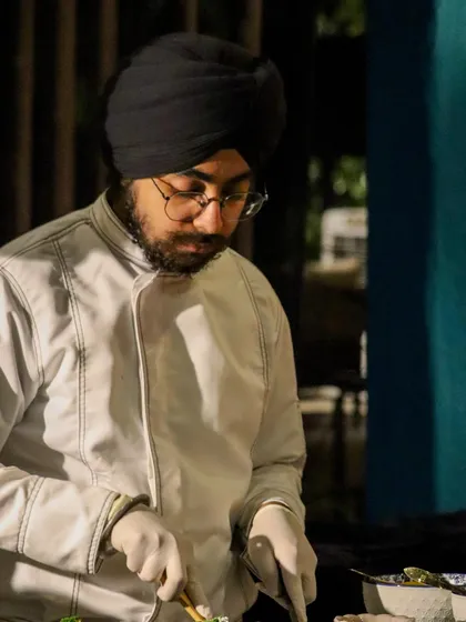 A chef concentrates on the intricate task of assembling a delicate dish, a testament to the skill and dedication of our team.