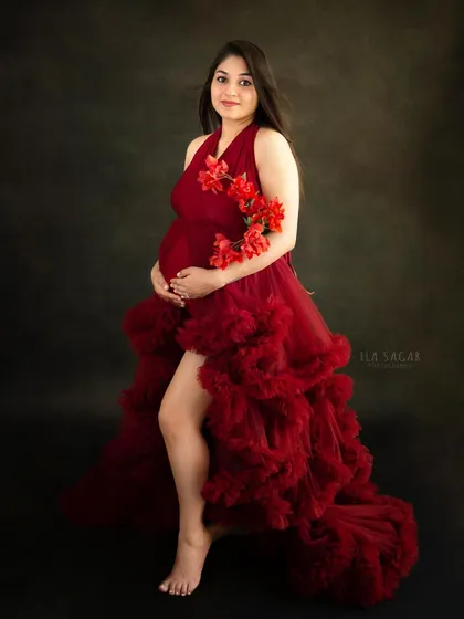 A maternity portrait should make you feel powerful and beautiful. I provide a selection of studio gowns, like this dramatic red one, and use simple props like flowers to create elegant, timeless images.