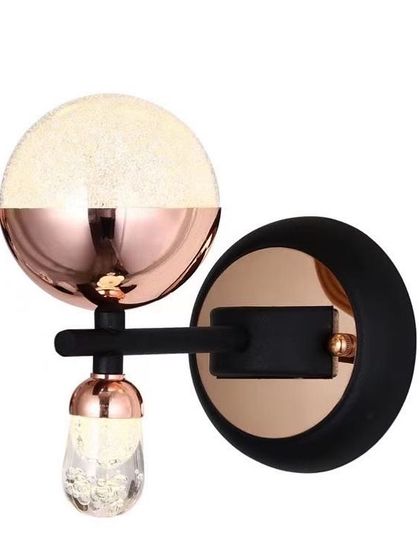 A playful wall sconce with a mix of rose gold, black, and textured glass. This piece is perfect for adding a pop of color and personality.