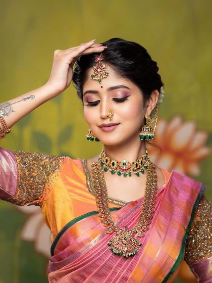 A close-up from a creative shoot, highlighting the detailed eye makeup and the traditional jewellery. The pose is elegant and showcases the makeup beautifully.