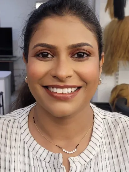 A warm, bronze-toned smokey eye paired with a glossy brown lip. This is a versatile and popular party makeup look that complements Indian skin tones beautifully.
