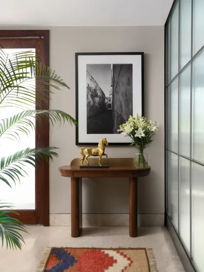 The entrance lobby is the first chapter of a home's story. Here, an elegant console from my Koko collection sets a tone of quiet luxury. I paired it with a vibrant kilim rug and a stark black and white photograph to create a curated corner that is both welcoming and intriguing.