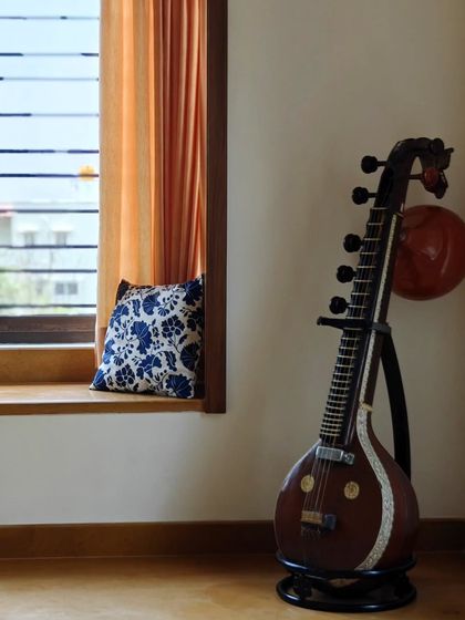 A detail shot of the bay window nook, featuring a traditional Indian musical instrument (veena). These personal touches add character and cultural context to the home.