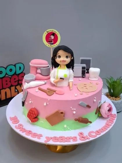 The full view of my 10th-anniversary cake, featuring a mini-me and all my baking tools.