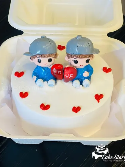 This cute bento cake is perfect for anniversaries or just to say "I love you." It features two adorable figures holding a heart, surrounded by tiny red heart sprinkles.