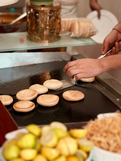 A chef preparing fresh kulchas on a hot tawa for our "Dilli-6 ka Matra Kulcha" station, bringing the authentic taste of Old Delhi street food to your event.