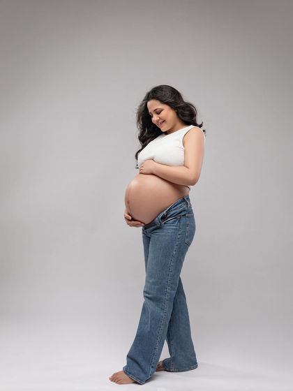 A sweet moment looking down at her bump. This relaxed style is perfect for capturing everyday, authentic moments of your pregnancy.