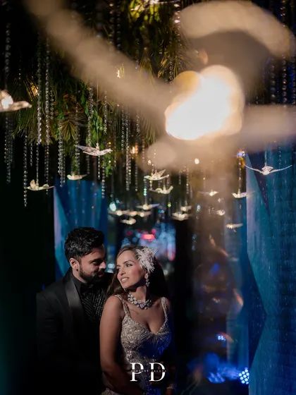 A romantic moment for the couple under the celestial-themed decor. The soft lighting and hanging crystal birds create a dreamy, intimate feel amidst the grand celebration.