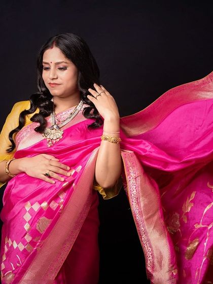 The beautiful flow of a saree's pallu. This shot captures the elegance and movement of the fabric, celebrating motherhood with traditional grace.