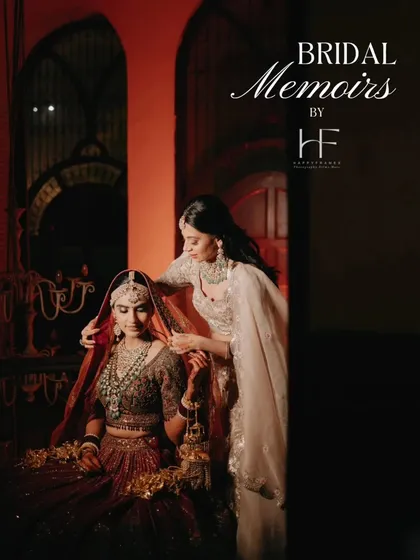 A 'Bridal Memoirs' shot showing a tender moment as the bride's sister or friend helps adjust her veil, captured with dramatic lighting.