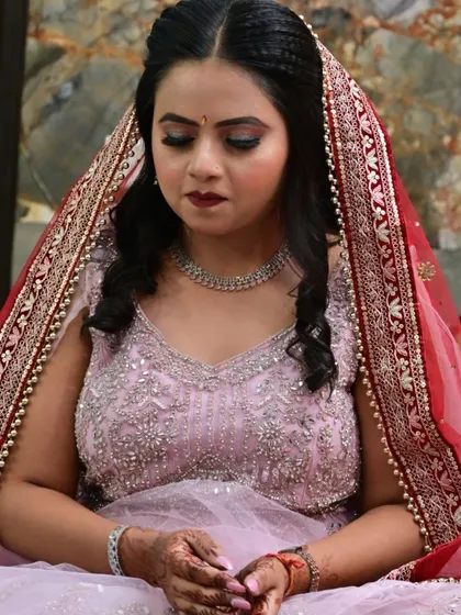 A beautiful shot of the bride looking down, showcasing her colorful eye makeup and bold lip.