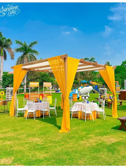A beautiful canopy seating area for a construction-themed party. The bright yellow drapes add a pop of colour to the lawn and provide a comfortable, shaded spot for guests to relax.