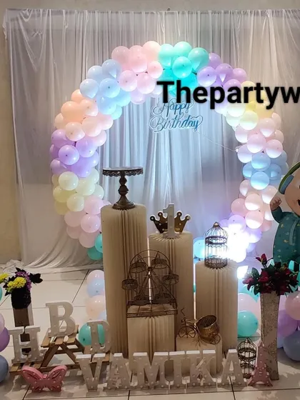 A Cocomelon theme with a pastel rainbow balloon ring. The soft colors and cute character cutouts make this a lovely choice for a first or second birthday.