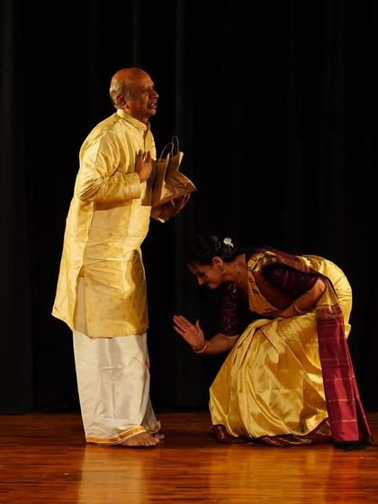 A moment of deep respect on stage. Here, a student pays homage to a senior artist, a gesture that embodies the humility and reverence that are central to our artistic traditions.