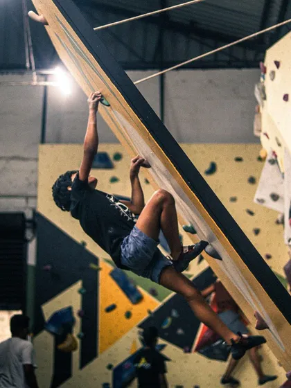 Even beginners get to tackle interesting challenges like this slight overhang. Our route setters design problems that are accessible but help you develop real climbing skills from day one.
