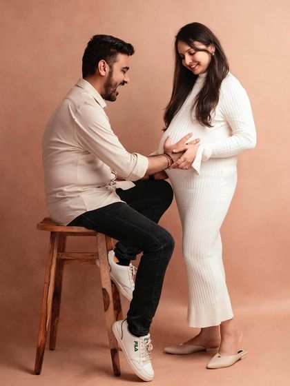 A candid moment of laughter and connection during a minimalist studio maternity session.