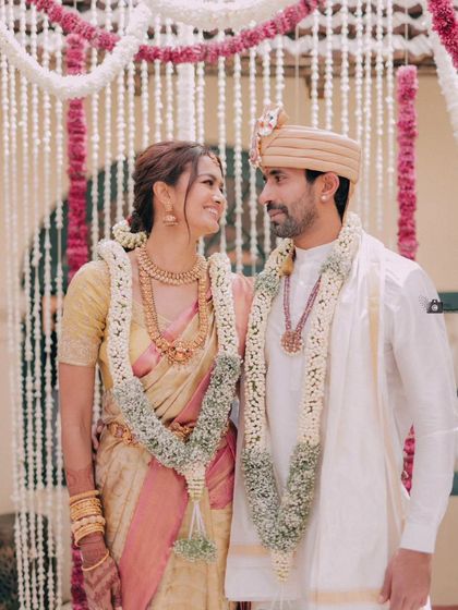 A classic portrait of the couple, their smiles and traditional garlands telling a story of love and togetherness.