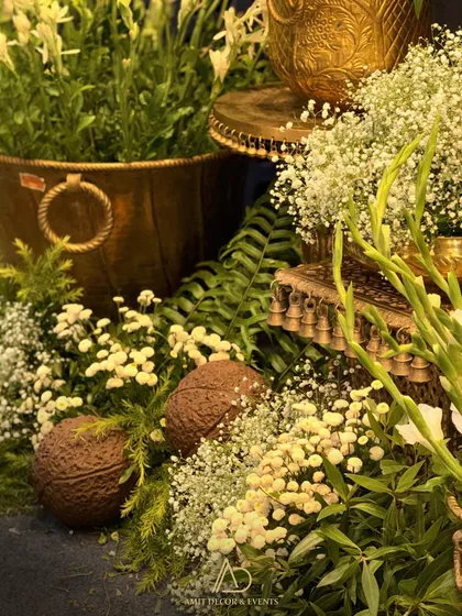 A detailed shot of the floral arrangements, featuring coconuts, gladiolus, and baby's breath in traditional brass and copper vessels.