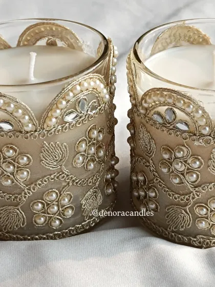 A close-up of the intricate embroidery and pearl work on the decorative jar candles.