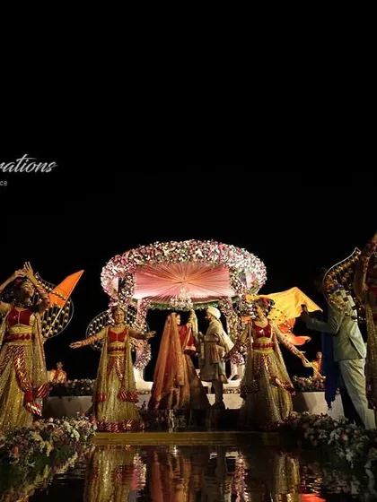 The dancers strike a pose during the beachside Jaimala ceremony in Goa. Their coordinated costumes and props add a layer of choreographed beauty to the couple's special moment.