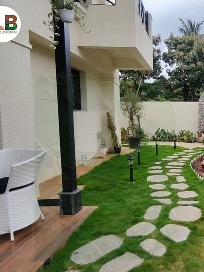 The final result of our backyard landscaping project. A winding stone path meanders through a fresh green lawn, bordered by carefully selected plants and subtle garden lighting, creating a picturesque and inviting outdoor area.