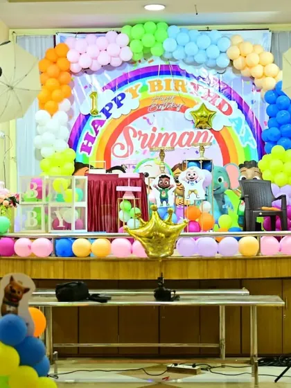 A bright and colorful Cocomelon-themed first birthday party. The rainbow backdrop and character cutouts create a fun and familiar world for the birthday boy.