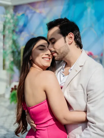 A joyful and candid embrace. The bride's bright smile and the couple's closeness make this a heartwarming and authentic portrait.