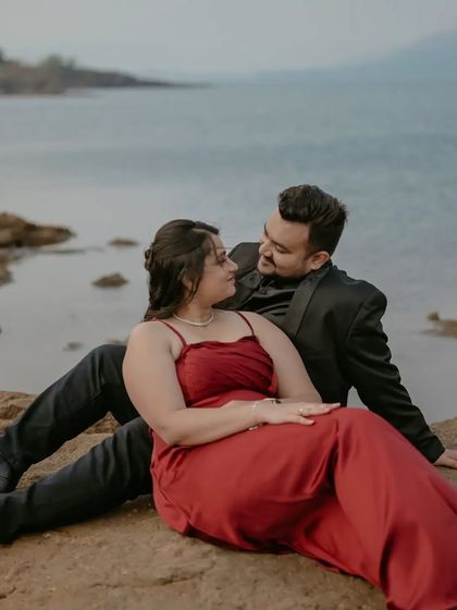A relaxed and romantic portrait of the couple lounging by the water during their pre-wedding session.