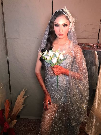 A full view of the sparkling silver gown. The makeup is designed to be elegant and timeless, perfect for a bride who wants a touch of Hollywood glam.