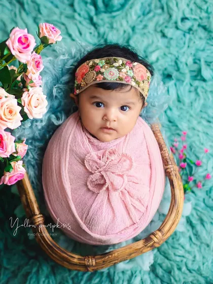 Wrapped in pink and surrounded by flowers. This newborn portrait combines a cozy swaddle with a beautiful floral theme for a delicate and artistic image.
