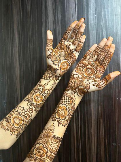 This full-arm floral design is a true statement piece. The patterns are continuous from the hand to the upper arm, creating a seamless and breathtaking bridal look.