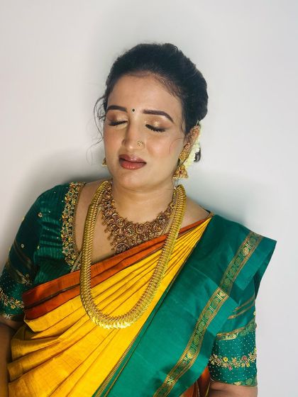 A close-up of Ramya's makeup. The soft gold and brown tones on her eyes perfectly complement her traditional yellow and green silk saree.