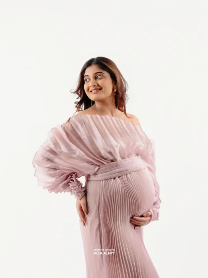 A high-key portrait in a pleated pink gown, showcasing a soft and romantic style.