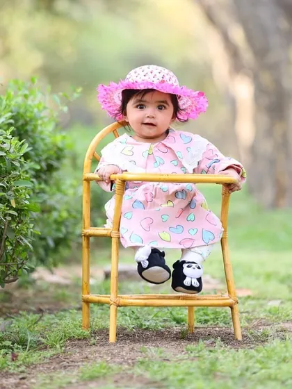 This sweet and simple outdoor portrait uses a classic prop to create a timeless image that focuses on the baby's adorable outfit and expression.