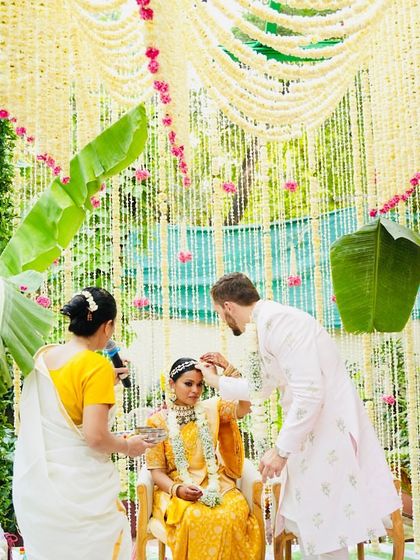 A sacred moment during the ceremony, framed by a stunning backdrop of tuberose garlands and banana leaves. This is what I mean by creating a minimal yet impactful setting for your vows.