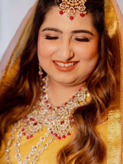 Capturing the joy of this bride's wedding ceremony. Her makeup is traditional and radiant, with warm tones and defined eyes, paired with soft waves for a look that is both classic and effortlessly beautiful.