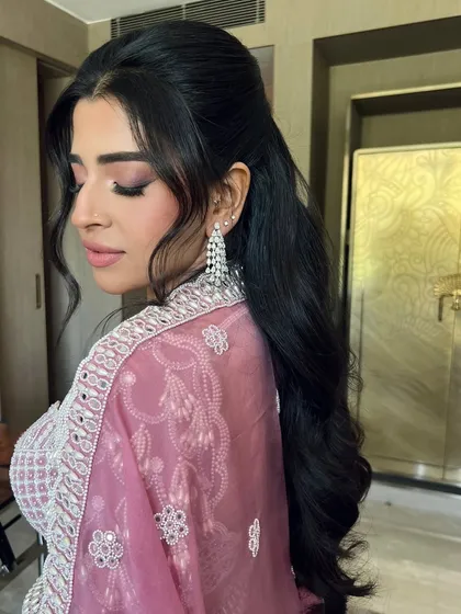 A side profile of the half-up style, showing soft tendrils framing the face for a romantic touch.