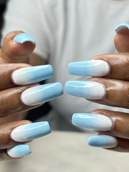 A fun shot showing the perfect blend of the blue sky ombre nails. The transition from white to blue is seamless and expertly done.
