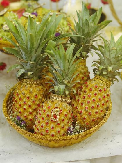A creative fruit display using decorated pineapples. I add small embellishments to the fruits to make them part of the overall decorative theme.