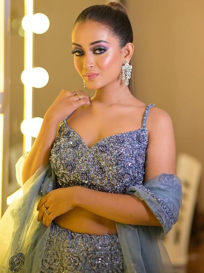 This dusty blue lehenga is adorned with intricate beadwork and sequins. The spaghetti-strap blouse adds a modern and delicate touch.