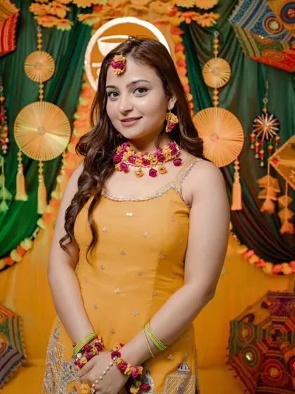 A bright and happy portrait of the Haldi bride, Nidhi. Her smile and colourful floral jewelry perfectly capture the spirit of the ceremony.