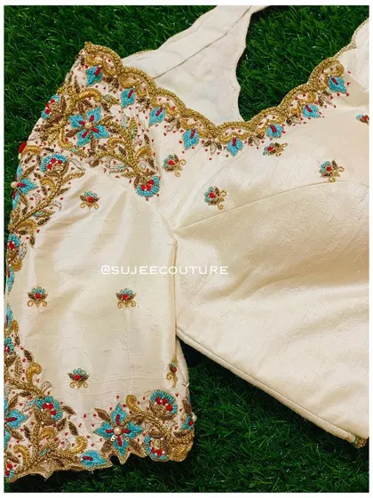A front view of the cream raw silk blouse, showing the sweetheart neckline and the placement of the floral embroidery on the sleeves and body.