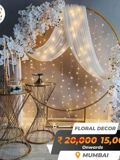 A modern and chic photo backdrop, featuring a golden circular frame, white florals, and elegant fairy lights. This decor package is available in Mumbai from ₹15,000.